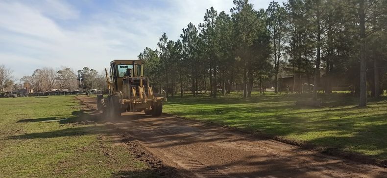 La motoniveladora empareja la pista de tierra.