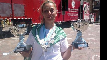 Mónica Brescasín muestra las dos copas: nacional y latinoamericana..
