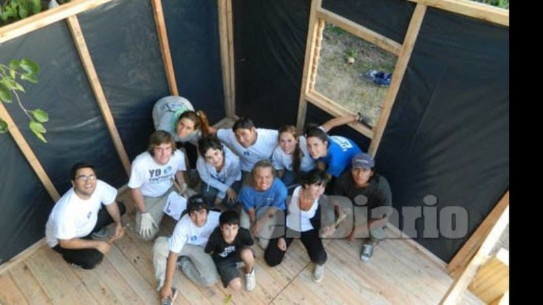 Casa nueva. Los voluntarios, frente a una de la viviendas construidas..