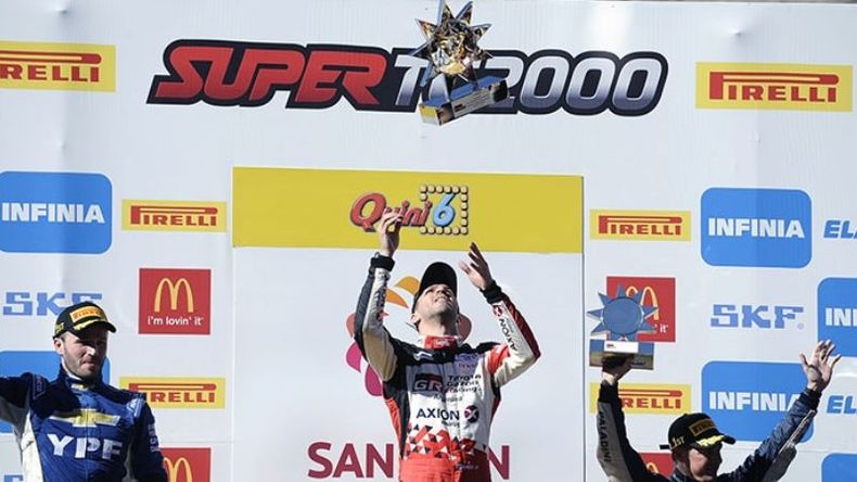 PODIO. Rossi lanza el trofeo tras lograr su primer triunfo en el año; lo custodian Canapino y Yannantuoni..