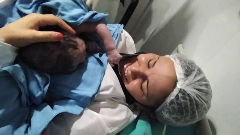 Amir se toma del tapabocas de su mamá..