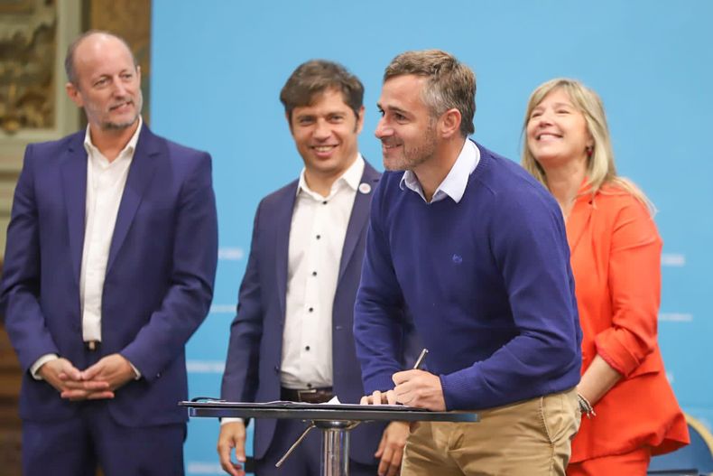 FIRMA. Achával rubrica el acuerdo ante las sonrisas de Insaurralde, Kicillof y Álvarez Rodríguez.