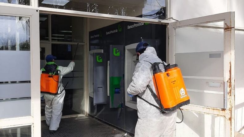 LIMPIEZA. Cuadrillas municipales desinfectan un cajero en Del Viso..
