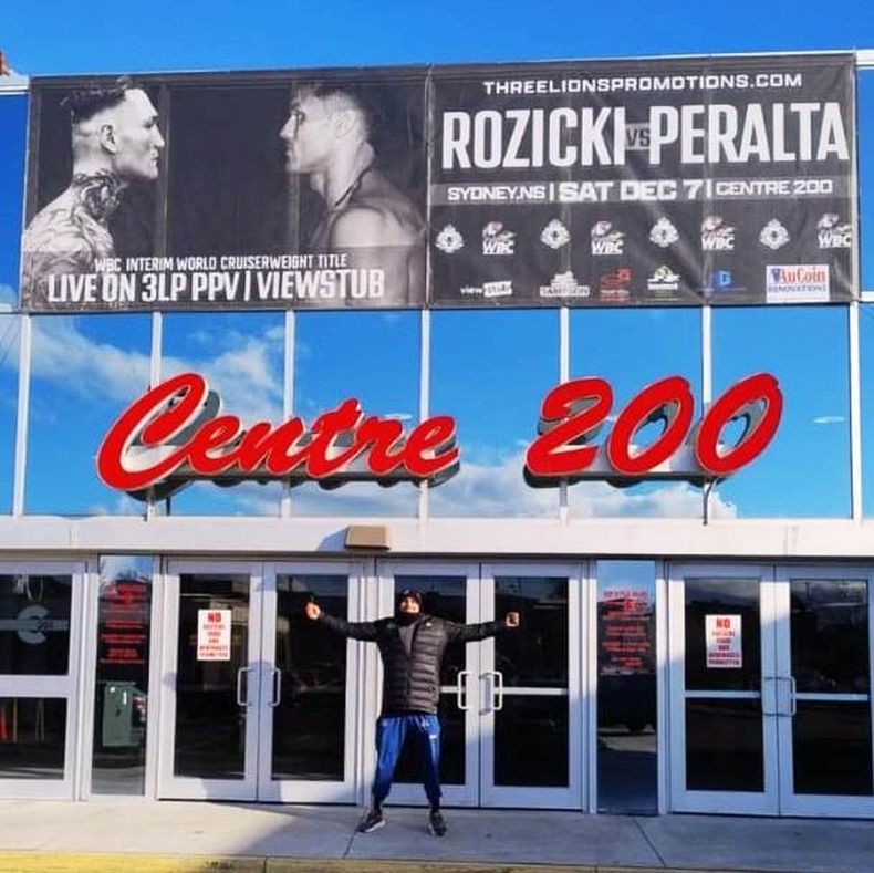 Yamil en la puerta del Centre 200 de S&iacute;dney y la cartelera promocional de la pelea.