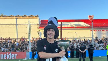 COPADO. La Mona Magallanes posa con la copa tras lograr el ascenso con Riestra en Córdoba.