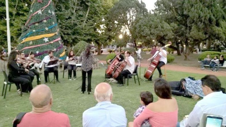 ORQUESTA EN LA PLAZA. En la noche del jueves, la Camerata Pilar brindó su concierto debut, en el marco de la inauguración del árbol de Navidad ubicado en la plaza 12 de Octubre. Obras clásicas, tangos y villancicos formaron parte del repertorio de la agrupación, compuesta por nueve instrumentos de cuerda (dos violines primeros, dos violines segundos, dos violas, dos cellos y un contrabajo), con jóvenes músicos profesionales surgidos de las audiciones que se llevan a cabo desde noviembre para conformar la Orquesta Sinfónica Municipal, más algunos intérpretes invitados. La dirección musical está a cargo de Clara Parodi y la producción artística, de la Dirección de Cultura del Municipio, desde donde indican que la orquesta “fue creada con la finalidad de generar un espacio sinfónico en servicio de la comunidad, permitiendo el acceso y descubrimiento de la música sinfónica”..