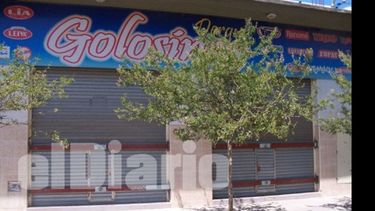 Una distribuidora con cortina metálica ciega y barras de acero..
