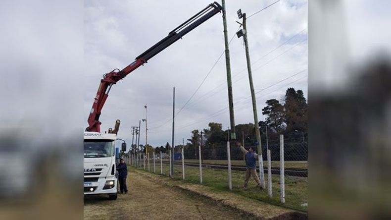 TRABAJO. La grúa levanta la columna de iluminación para la cancha..