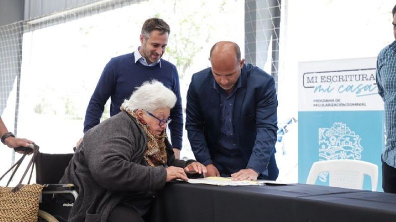 FIRMA. El intendente acompañó a los vecinos que recibieron las escrituras de sus casas..