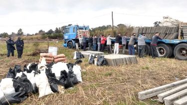 APREHENDIDOS. Los detenidos y los materiales que iban a utilizar para cercar el predio. .