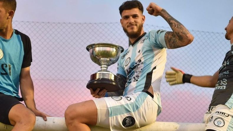 COPADO. Palpacelli subido al arco y con la copa de campeón en la cancha de Argentino..