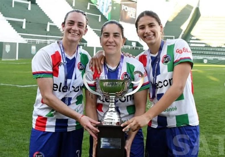 Cata Núñez y Antonella Escurra con la capitanaGisel García con la Copa de Invierno.