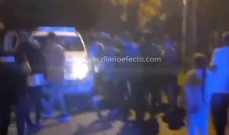 La gente rodea al móvil policial.