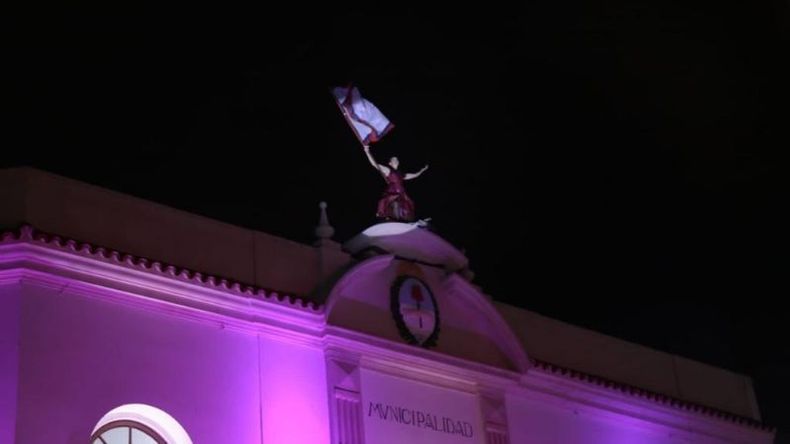 Performance de una bailarina agitando la bandera de Pilar sobre el tecno de la municipalidad..
