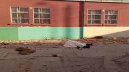 El cuerpo del auxiliar quedó en el patio de la escuela (foto Infobae)..