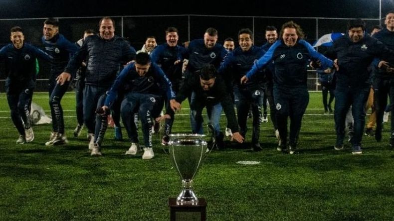 RITUAL. Jugadores y cuerpo técnico se tiran de palomita ante la copa..