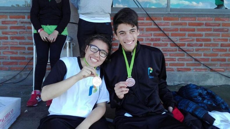 Rosario del Río y Franco Núñez lucen orgullosos su medallas de atletismo..
