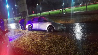 TEMPORAL. Un auto encajado en la zanja sobre la calle 7 en el Parque Industrial.
