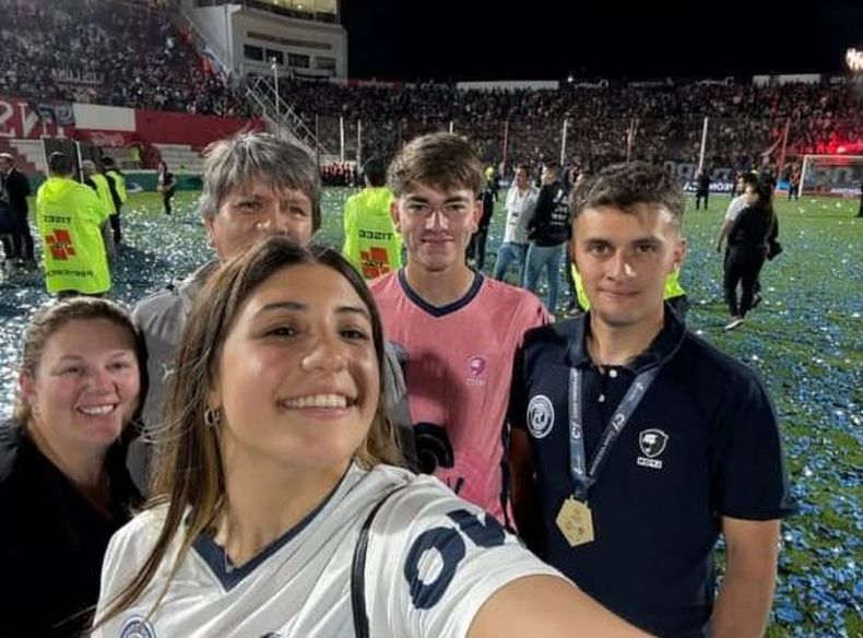 MEDALLA. Santiago Flores posa junto a sus familiares en la cancha de Instituto, tras la consagración.