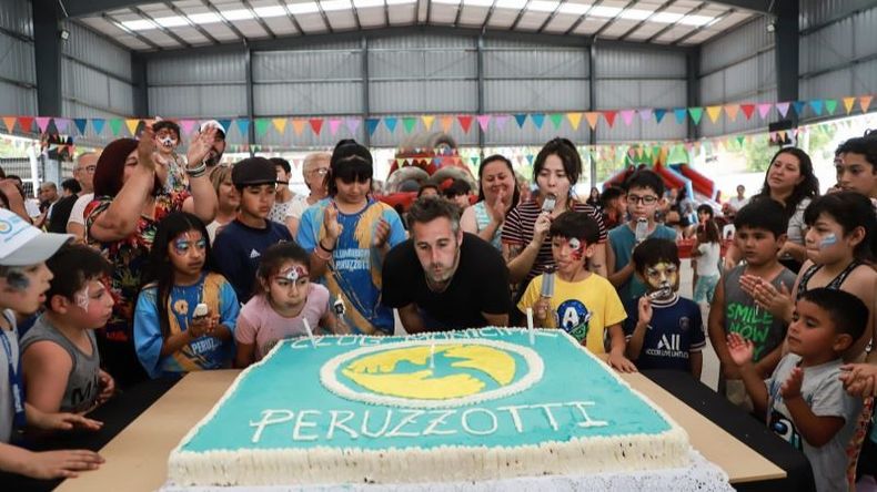 TORTA. El intendente sopla la primera vela junto a los chicos de Peruzzotti. .