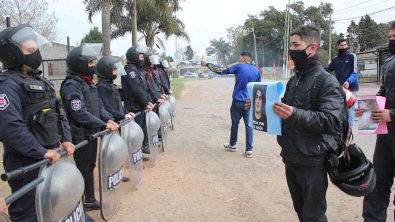 Manifestantes le muestran a los policías la foto del presunto autor material, que está prófugo..