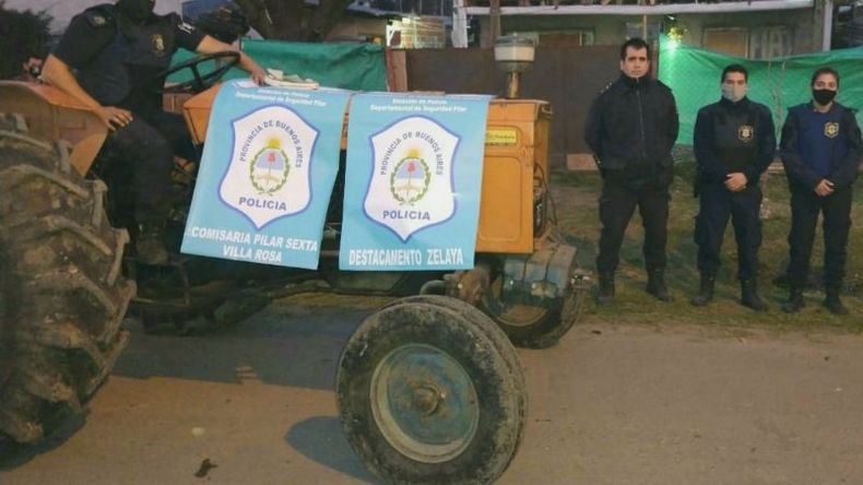 Los policías junto al tractor recuperado..