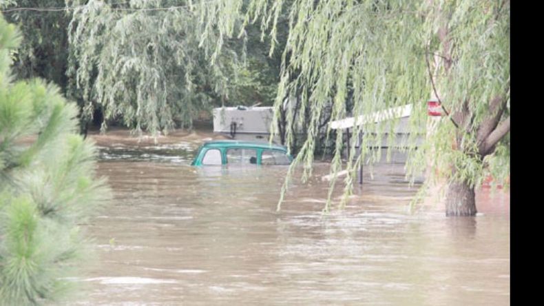 El techo del R 4 asoma del agua, en el barrio Río Luján..