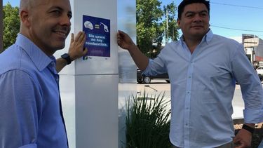 De la mano. Ducoté y su reemplazante de verano, Miguel Gamboa, pegaron el cartel indicatorio en la YPF de ruta 8 y AV. Tratado del Pilar. .