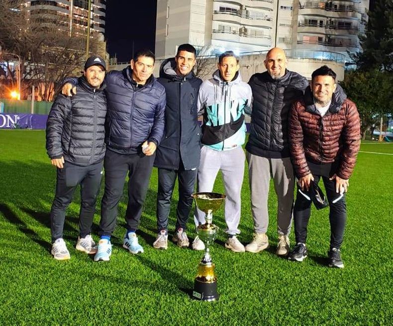 El cuerpo t&eacute;cnico de Somra, encabezado por Hugo Silva (der.), posa con la copa tras ganar el Reducido.