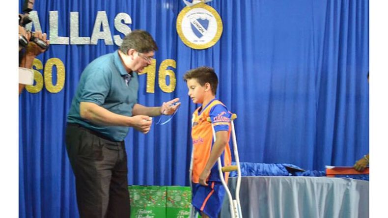 PREMIO. Carlotto premia a Santi Fretes, del fútbol infantil..