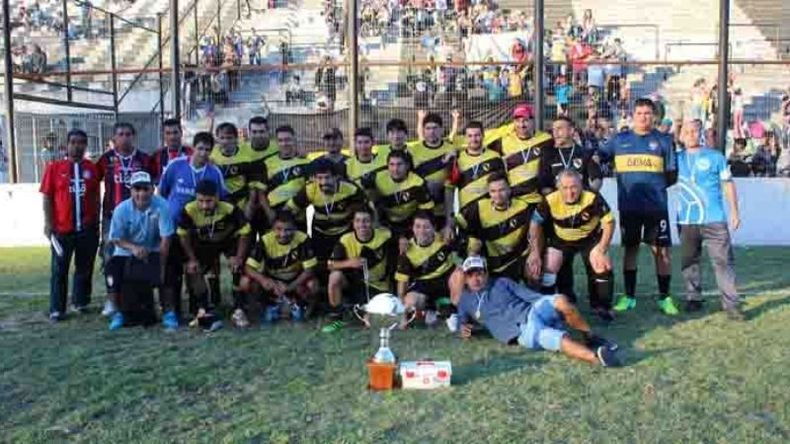 ESCOLTA. 25 de Mayo B posa, con su gente de fondo, con la copa de subcampeón..
