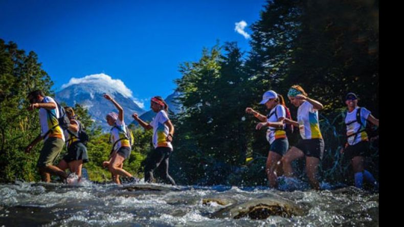 TRAVESÍA. Los atletas cruzan el río con el volcán Lanín de fondo..