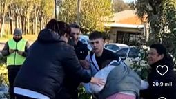 Vecinos intentaron llevarse las botellas caídas del camión y forcejearon con personal de seguridad que custodiaba la carga. Foto: Captura video TN. Vecinos intentaron llevarse las botellas caídas del camión y forcejearon con personal de seguridad que custodiaba la carga. Foto: Captura video TN.