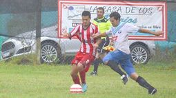 DOBLETE. Walter Díaz forceja con un rival bajo la lluvia del domingo..