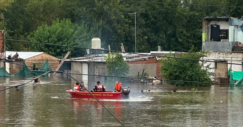 BOMBEROS. Una lancha recorre la zona del río Luján. Su desborde afectó al barrio del mismo nombre.