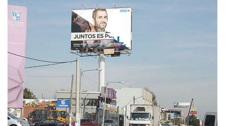 CAMBIO. El momento en que el cartel oficialista tapa el de Achával..