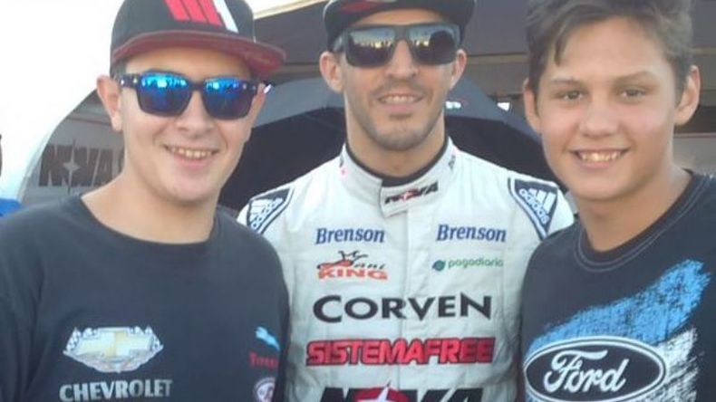 Hinchas del piloto. Rossi, en los boxes de Concepción, posa junto a un fanático de Chevrolet y otro de Ford..