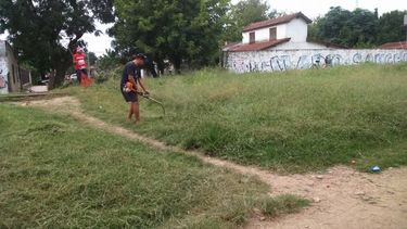 Vecino corta el pasto en el paso a nivel Mitre. Foto Matías Godoy..