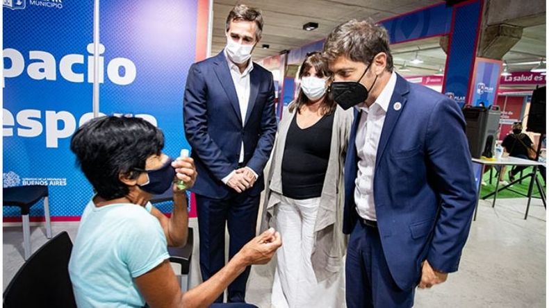 CHARLA. Kicillof dialoga con una vecina, junto Achával y García, en el vacunatorio del kilómetro 46..