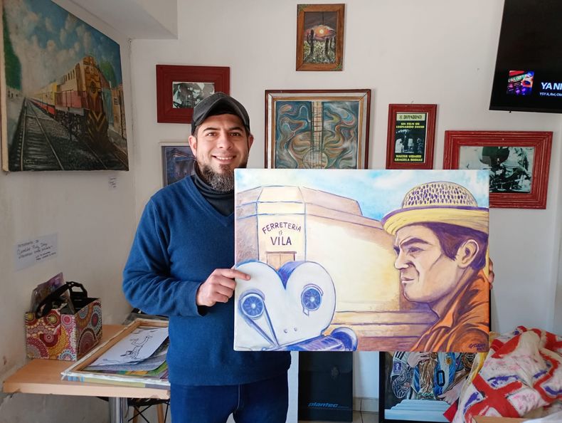 El artista Gussram con su cuadro de Leonardo Favio en la esquina de la Ferretería de Vila.&nbsp;