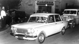El Fiat 1500 es uno de los grandes autos de la época. En esta imagen de la década de 1970, su dueño lo exhibe con orgullo en el centro de Presidente Derqui, durante una carrera nocturna de regularidad. .