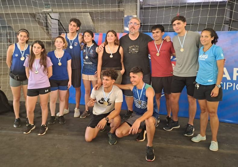 MEDALLAS. Los atletas de la Escuela Municipal posan con sus reconocimientos junto a los profes.