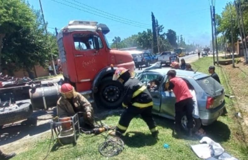 ATRAPADA. Los bomberos intentan rescatar a la mujer del interior del auto.