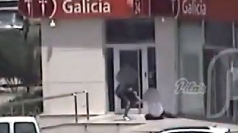 El ladrón forcejea y la víctima está en el suelo..
