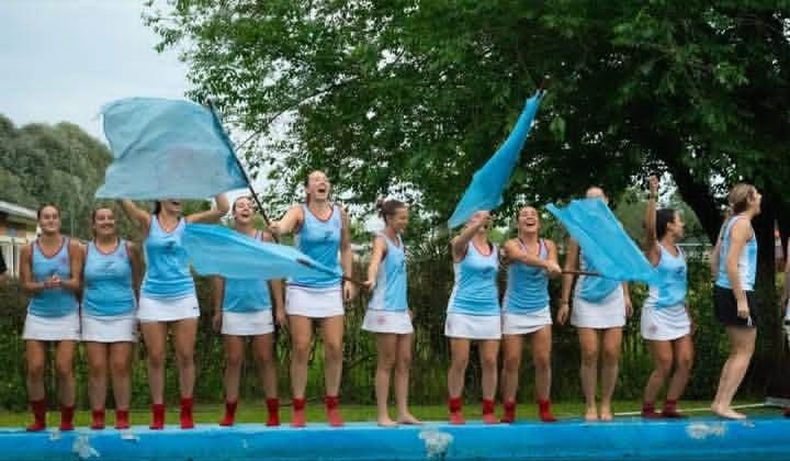 PILETAZO. Las chicas de Sanpa festejan con banderas el ascenso al lado de la pileta.