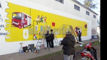 Los chicos, en plena confección del mural que los representa..
