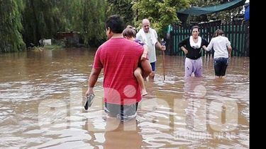 Vecinos de Villa Verde, ayer, tratando de desplazarse por las calles del barrio. Hubo más de un metro de agua en las casas..