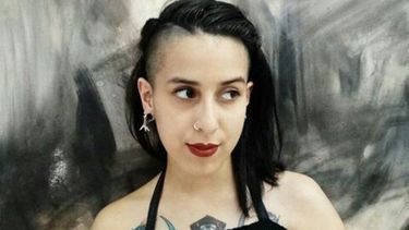 Carrie Bencardino en primer plano con una obra propia de fondo..
