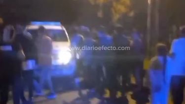 La gente rodea al móvil policial.