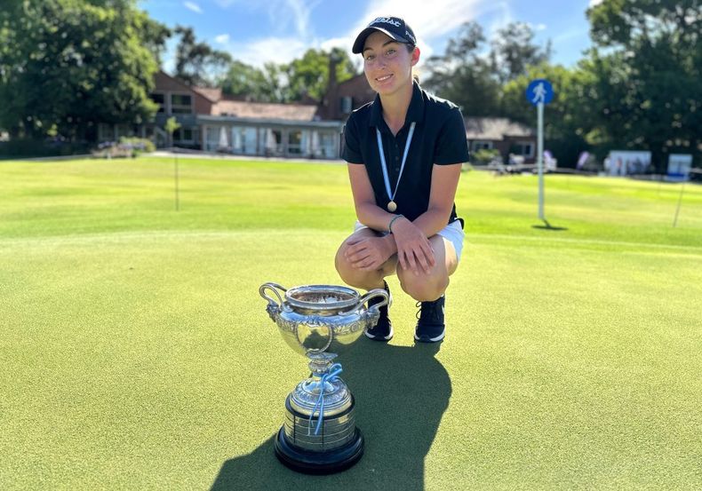 NUEVA REINA. Malena Castro posa con la copa de campeona en la cancha del GC Argentino, en Del Viso.